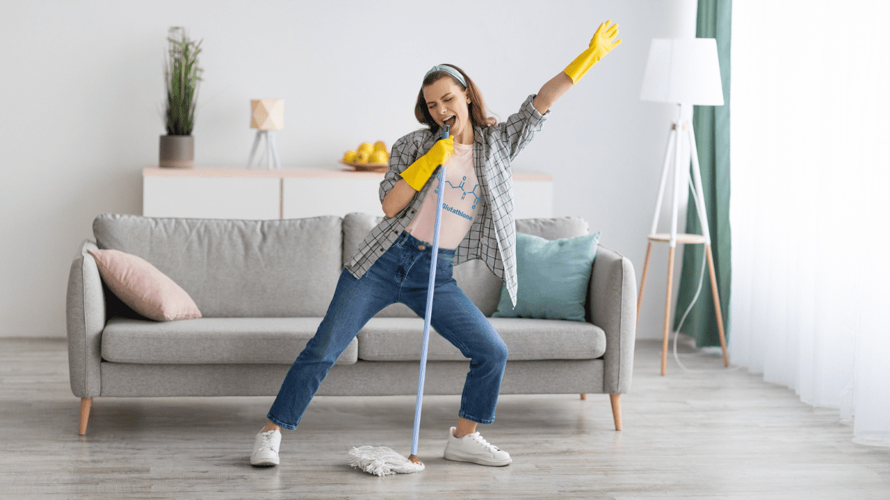 Woman mopping and singing into the mop handle with "glutathione" on her shirt