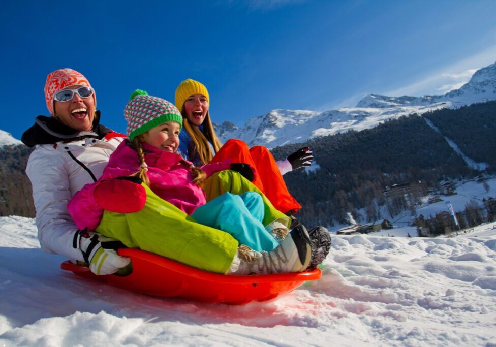 Winter fun, snow, family sledding at winter time