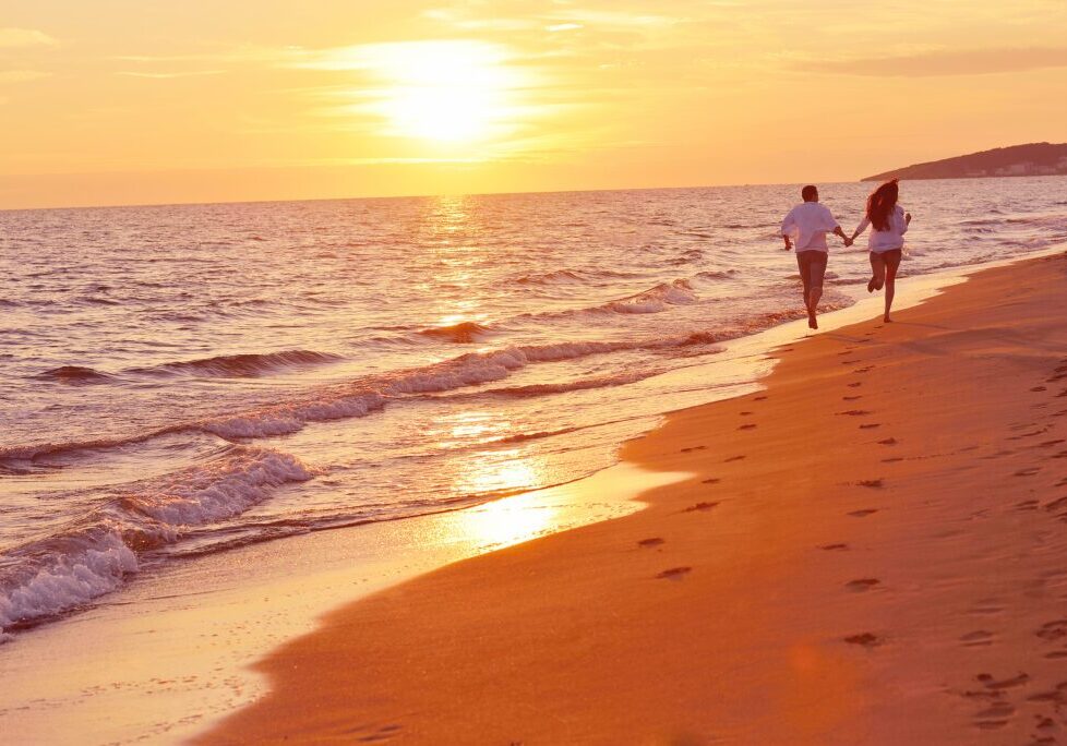 happy young romantic couple in love have fun on beautiful beach at beautiful summer day