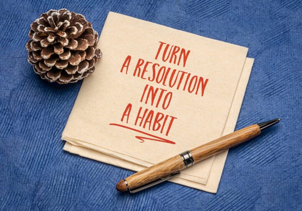 turn a resolution into a habit inspirational advice or reminder on a napkin, New Year resolutions, setting goals and personal development concept