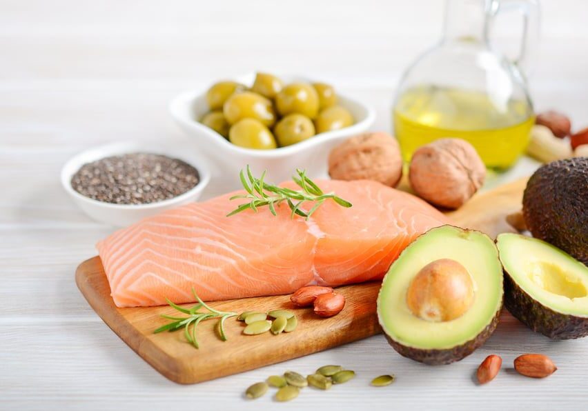 salmon, olives, avocados on a plate