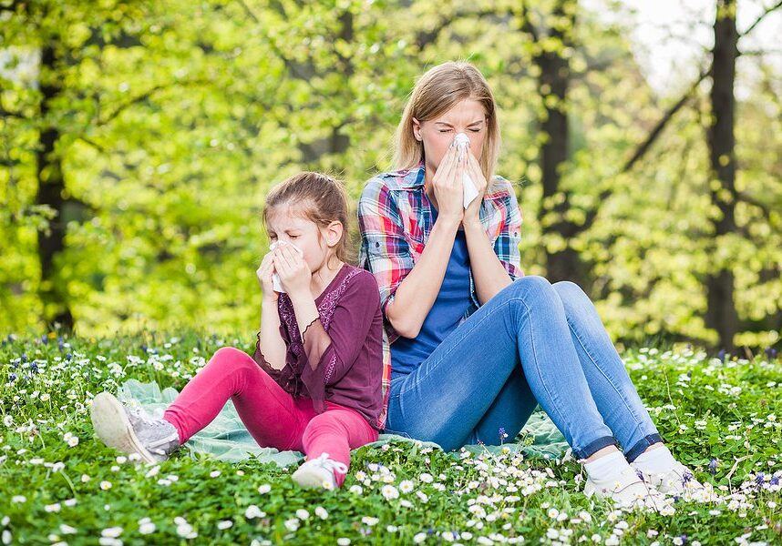 mother daughter outside sneezing