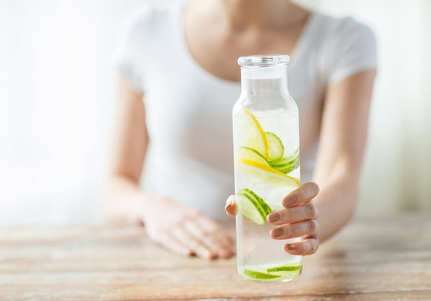 woman white top holding detox water